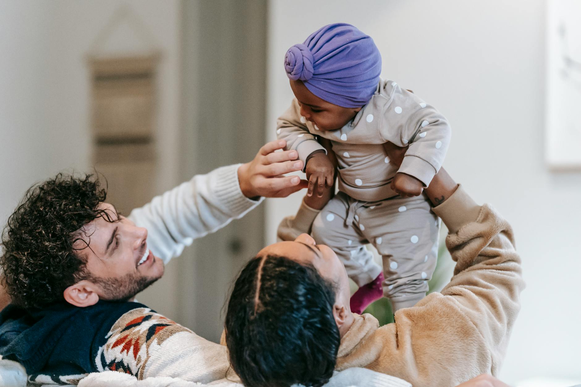 Mama i tata rozmawiają z małym dzieckiem na kanapie w salonie