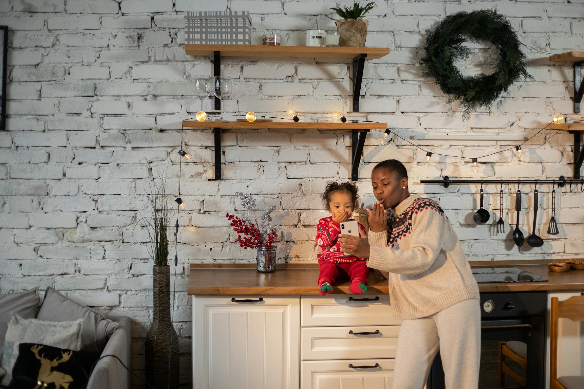 Mama z trzylatkiem rozmawiają z bliskimi na wideo w świątecznej kuchni