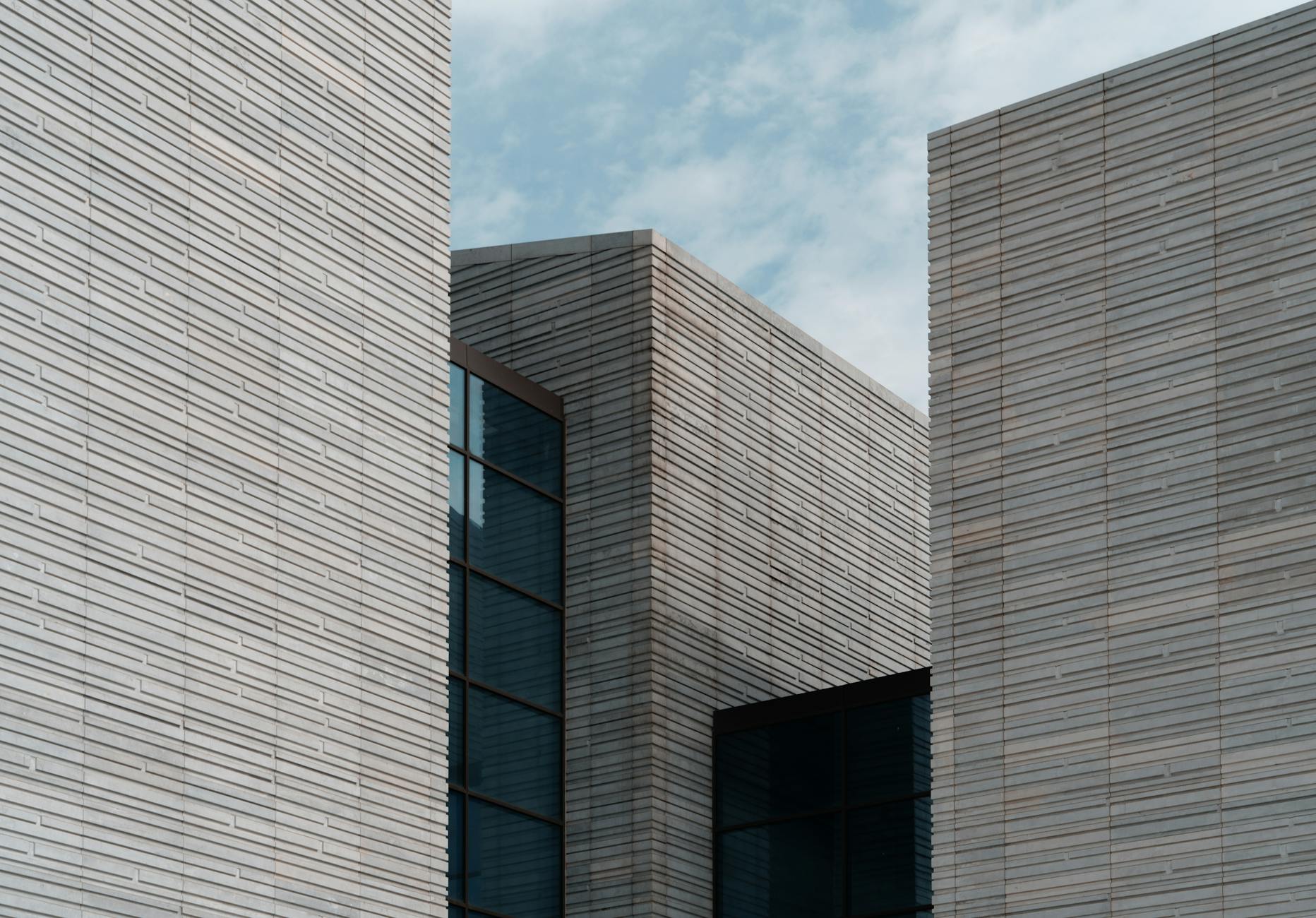 Minimalistyczna elewacja nowoczesnego budynku na tle błękitnego nieba