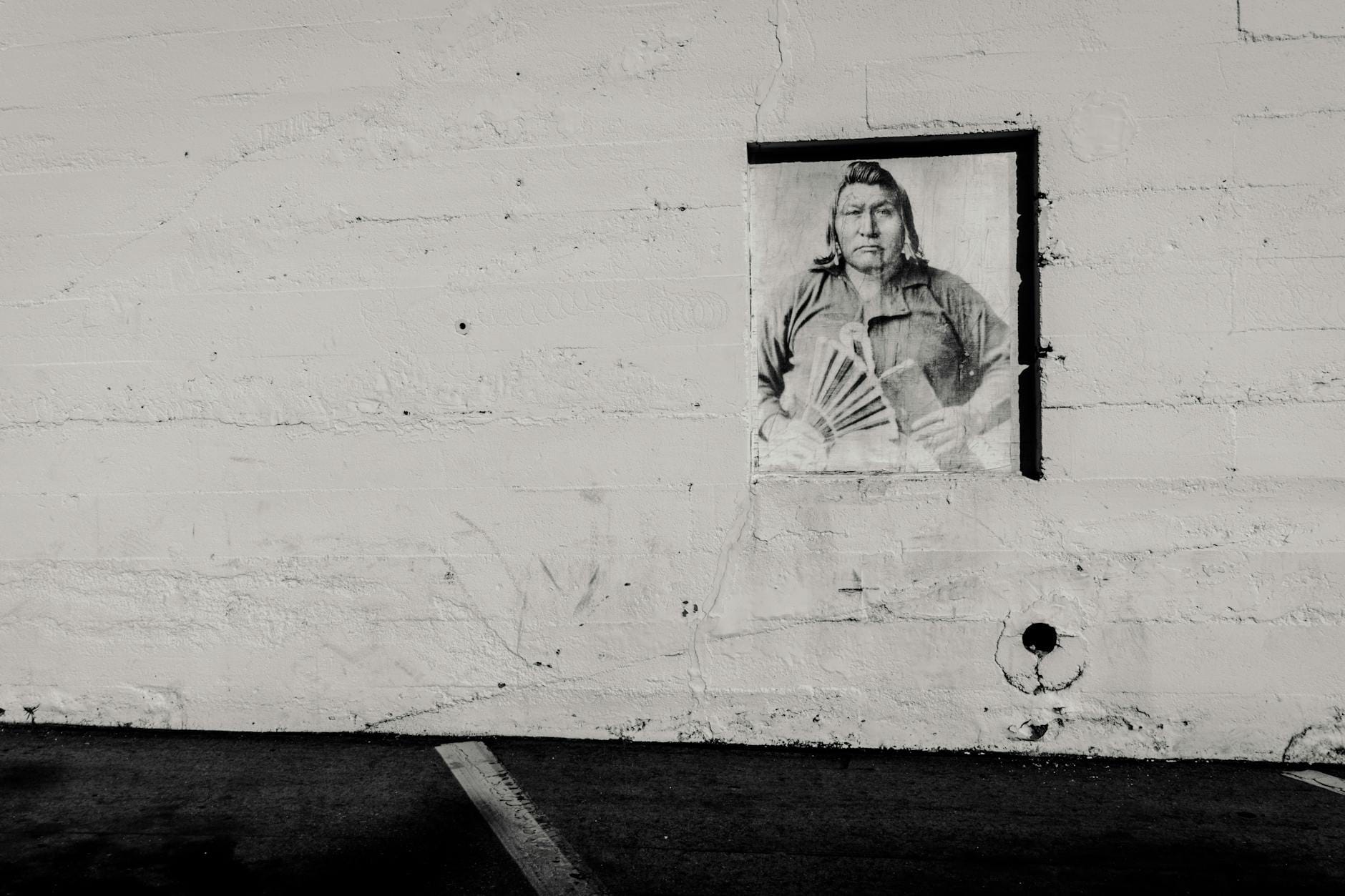 Czarno-biały mural historycznej postaci na ścianie z betonu architektonicznego