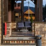 Górski domek z tarasem z płyt, drewnianymi i kamiennymi elementami