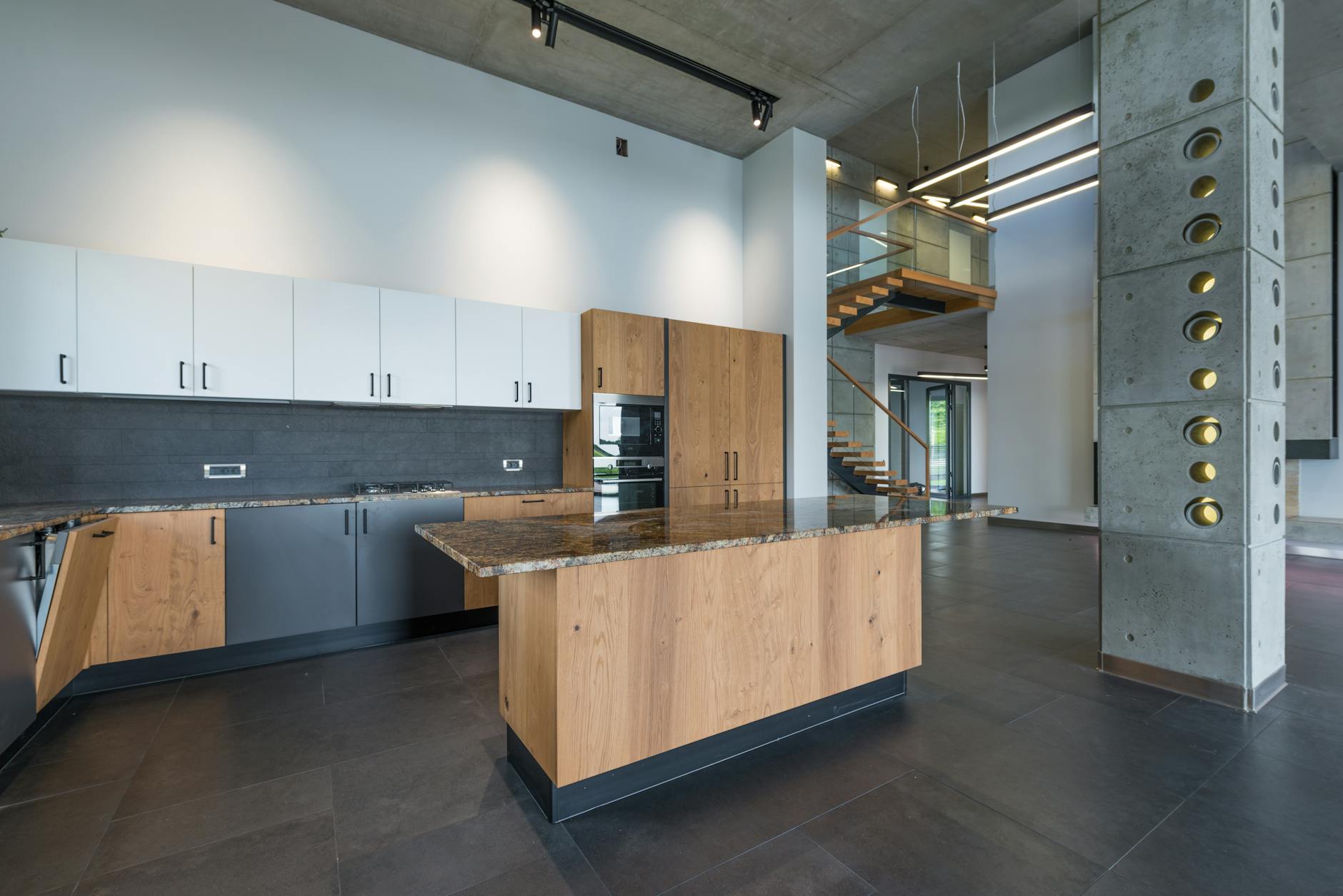 Jasna kuchnia z kolorowymi szafkami i drewnianym stołem przy ścianie