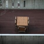 Minimalistyczny taras z drewnianymi stołami i ścianami z betonu architektoniczne