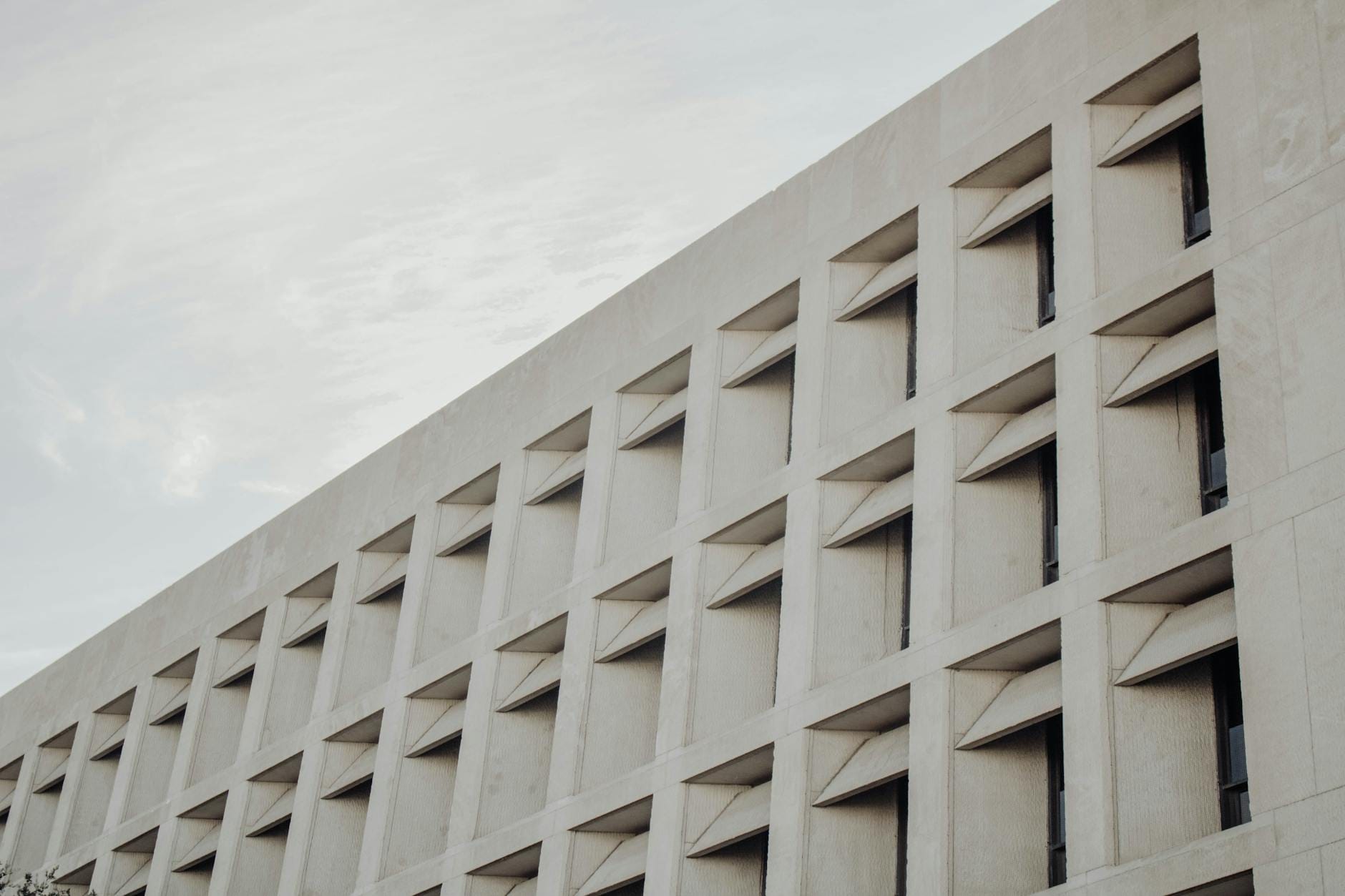 Beton architektoniczny na elewacji: trwałość i pielęgnacja Nowoczesna elewacja z betonu architektonicznego widziana z dołu