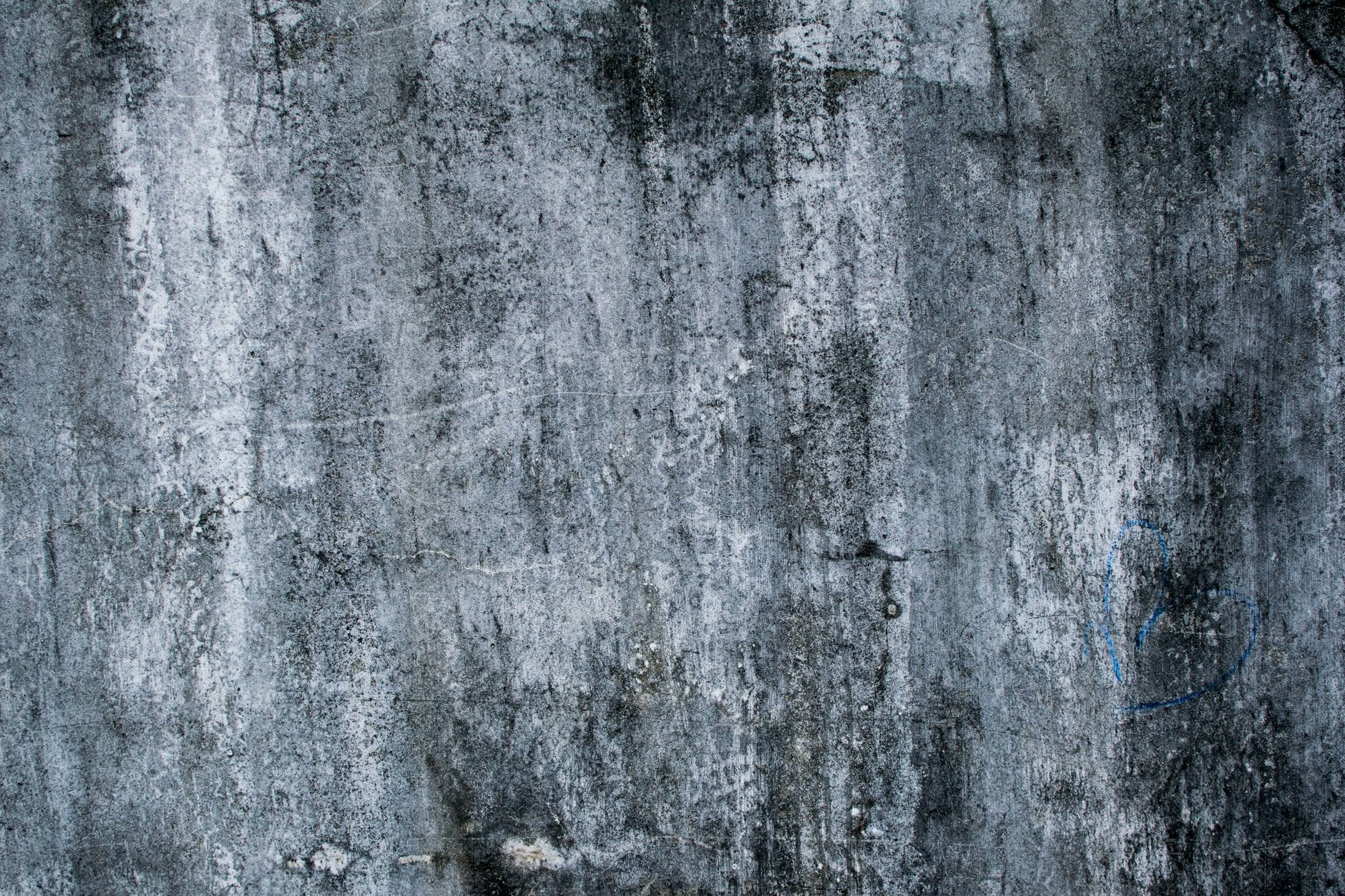 Chropowata ściana z betonu z delikatnym sercem z graffiti