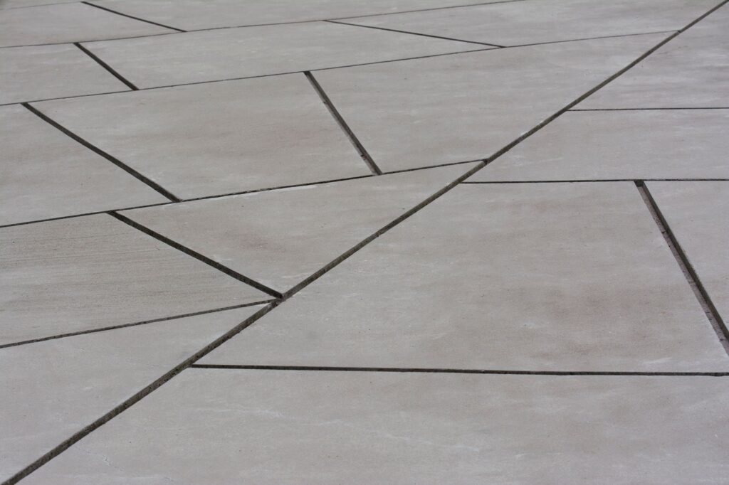Abstrakcyjna betonowa powierzchnia z przecinającymi się liniami geometrycznymi
